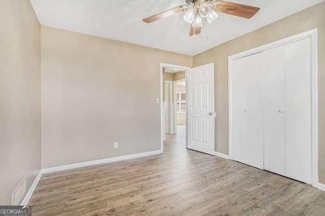 unfurnished bedroom featuring a closet, ceiling fan, and light wood-type flooring