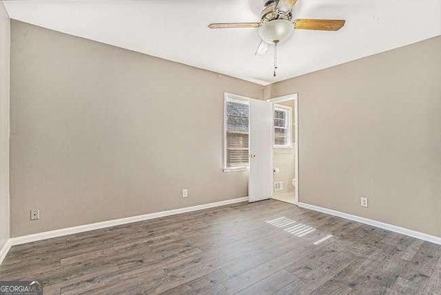 unfurnished room featuring dark wood-type flooring and ceiling fan