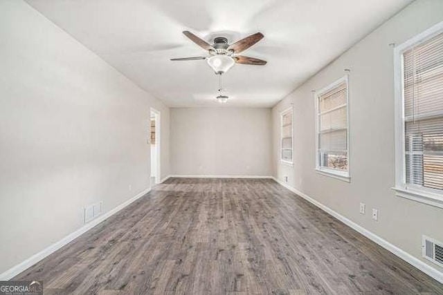 unfurnished room featuring dark wood-type flooring and ceiling fan