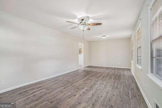 empty room featuring dark wood-type flooring and ceiling fan