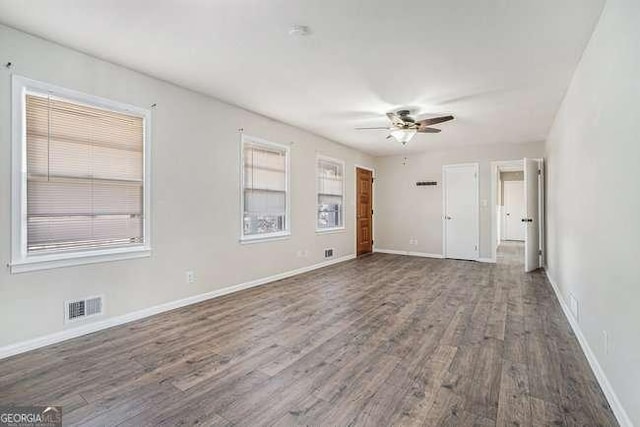 empty room with hardwood / wood-style flooring, plenty of natural light, and ceiling fan