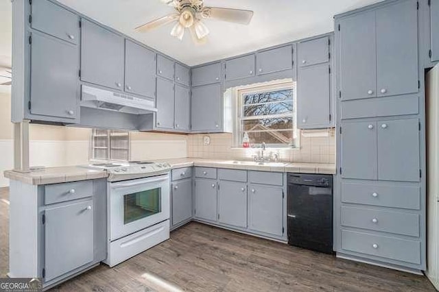 kitchen with black dishwasher, tile countertops, electric range, and dark hardwood / wood-style flooring