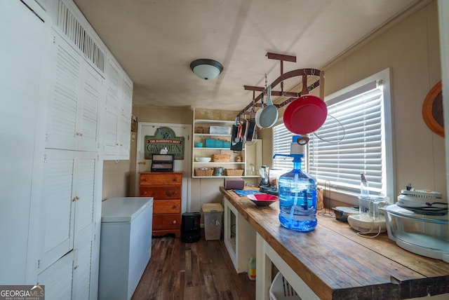 kitchen with butcher block counters, fridge, and dark hardwood / wood-style floors