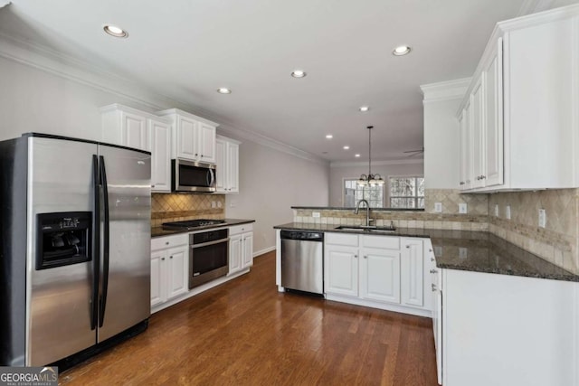 kitchen with sink, white cabinetry, hanging light fixtures, kitchen peninsula, and stainless steel appliances