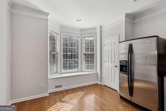 kitchen with stainless steel fridge, ornamental molding, and wood-type flooring