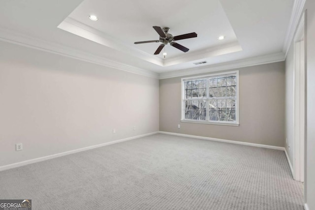 spare room with ornamental molding, a raised ceiling, ceiling fan, and carpet