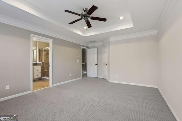 unfurnished bedroom with connected bathroom, ornamental molding, carpet flooring, a raised ceiling, and ceiling fan