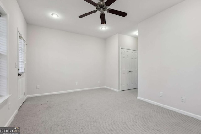 carpeted spare room featuring ceiling fan