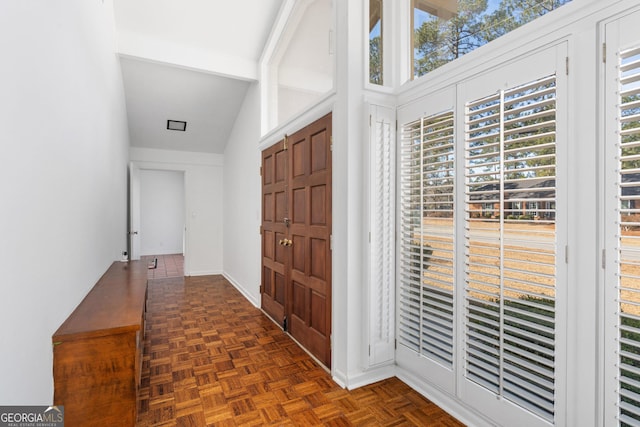 entryway featuring beamed ceiling and dark parquet floors