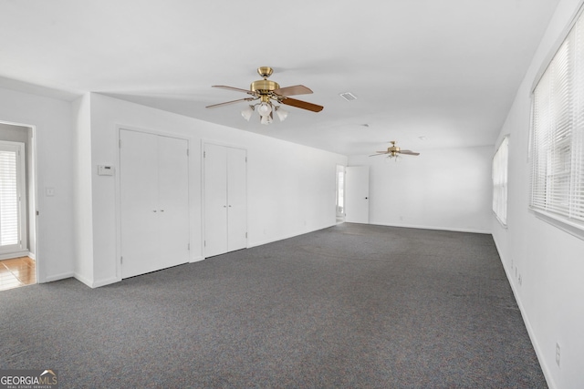 empty room featuring dark colored carpet and ceiling fan