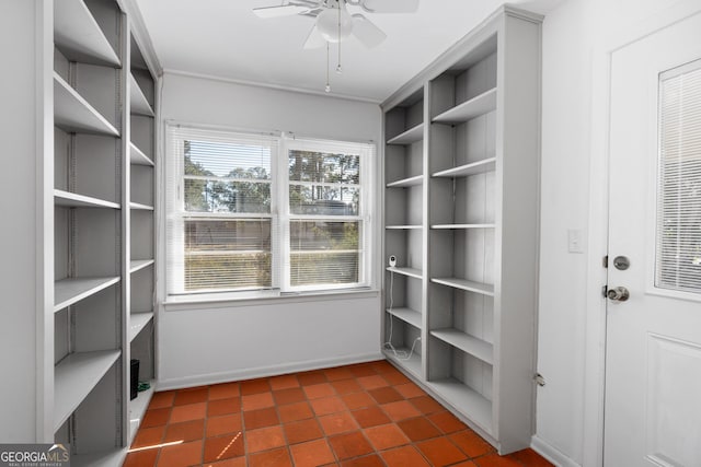 spacious closet with dark tile patterned floors and ceiling fan