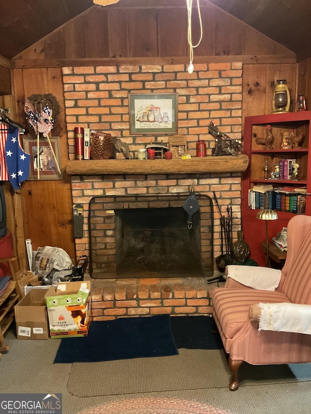 living area with carpet floors, a fireplace, vaulted ceiling, and wood walls