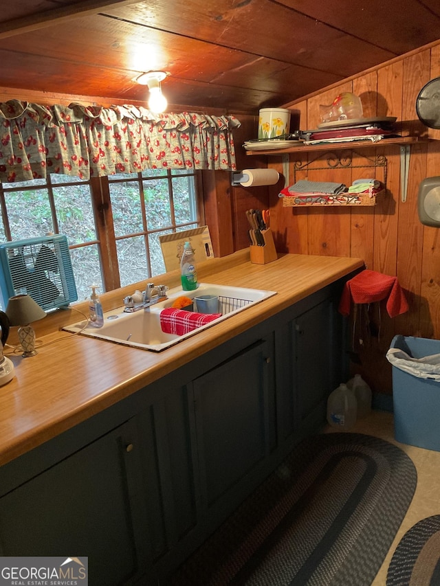 kitchen featuring wood ceiling, wooden walls, sink, and vaulted ceiling