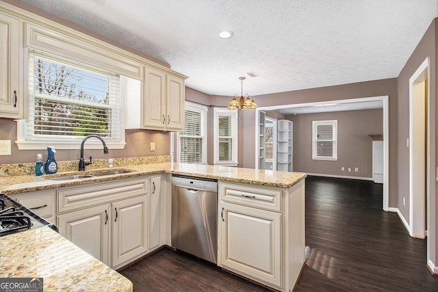 kitchen featuring pendant lighting, sink, dark wood-type flooring, stainless steel dishwasher, and cream cabinetry