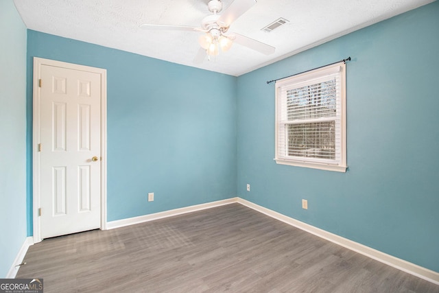 unfurnished room featuring a textured ceiling, wood-type flooring, and ceiling fan