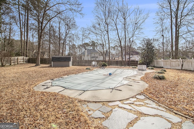 exterior space with a patio area, a covered pool, and a storage unit