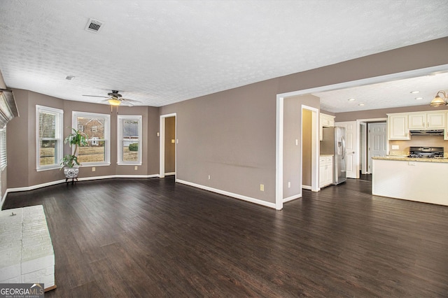 unfurnished living room with ceiling fan, dark hardwood / wood-style floors, and a textured ceiling