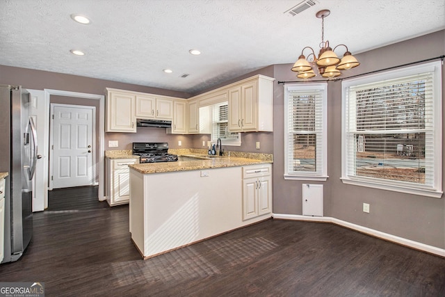 kitchen featuring stainless steel refrigerator, range, light stone countertops, dark hardwood / wood-style flooring, and decorative light fixtures