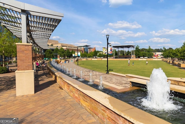 surrounding community featuring a pergola and a lawn