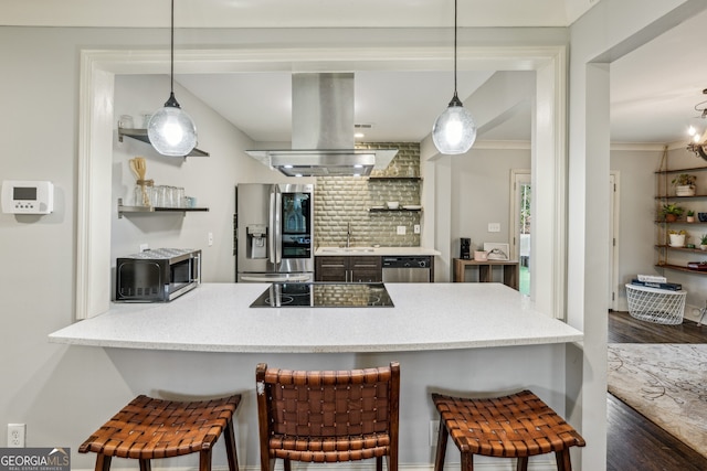 kitchen with stainless steel appliances, island exhaust hood, a breakfast bar area, and pendant lighting