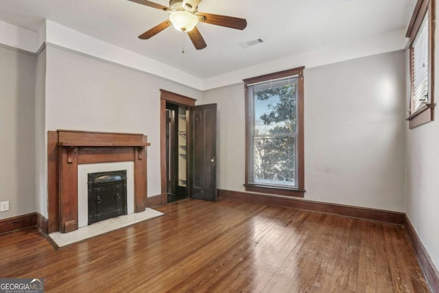 unfurnished living room featuring hardwood / wood-style flooring, plenty of natural light, and ceiling fan