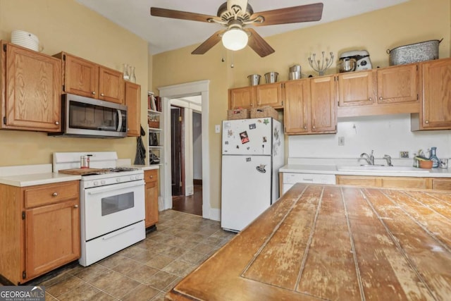 kitchen featuring ceiling fan, sink, and white appliances