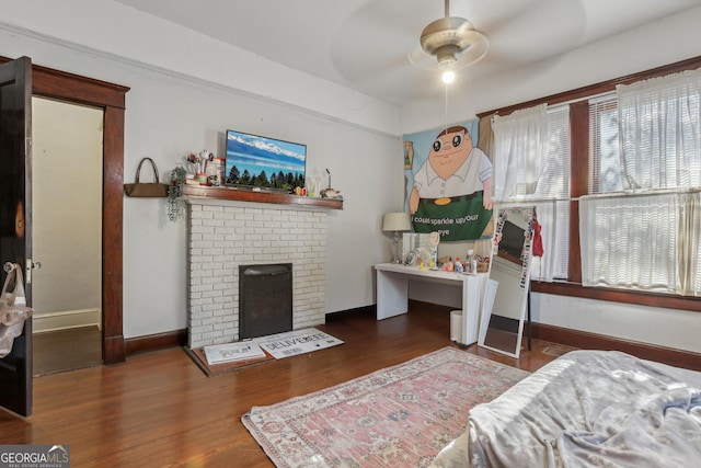 bedroom featuring dark hardwood / wood-style flooring and a brick fireplace