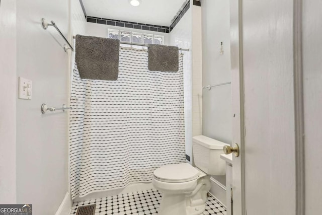 bathroom featuring toilet and a shower with shower curtain