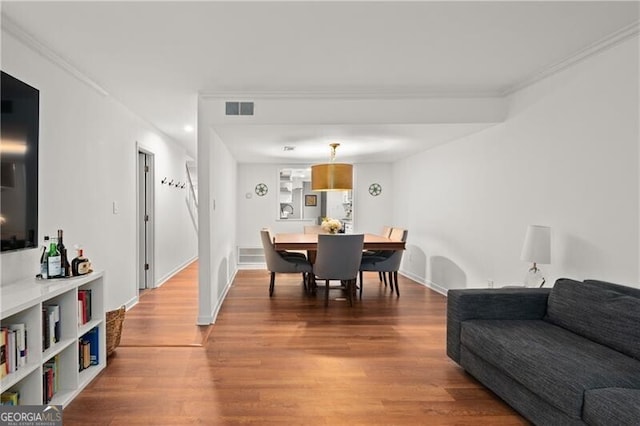 dining space featuring crown molding and hardwood / wood-style floors