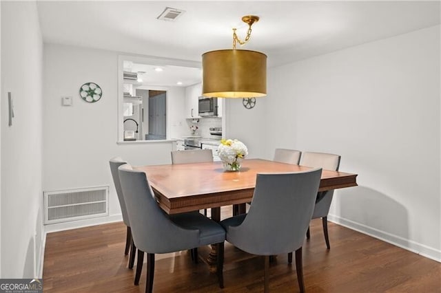 dining area with dark hardwood / wood-style floors and sink