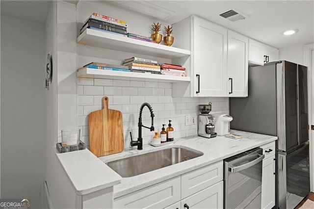 kitchen featuring white cabinetry, sink, backsplash, and stainless steel appliances