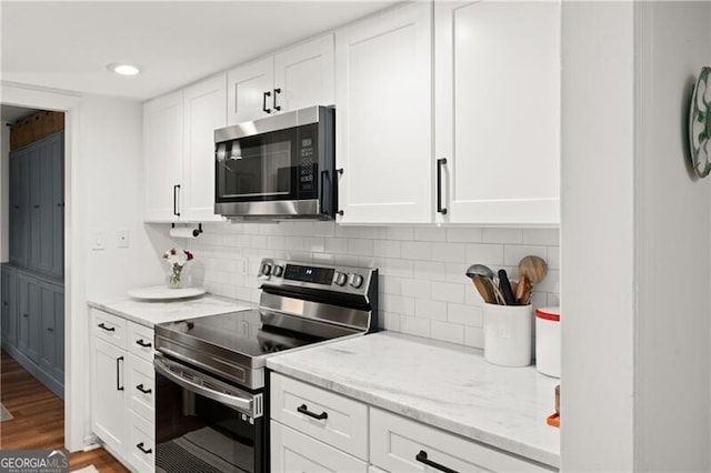 kitchen featuring light stone counters, appliances with stainless steel finishes, hardwood / wood-style floors, decorative backsplash, and white cabinets