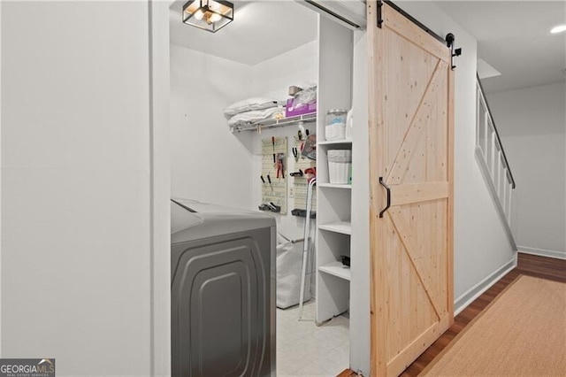 laundry room with independent washer and dryer and a barn door