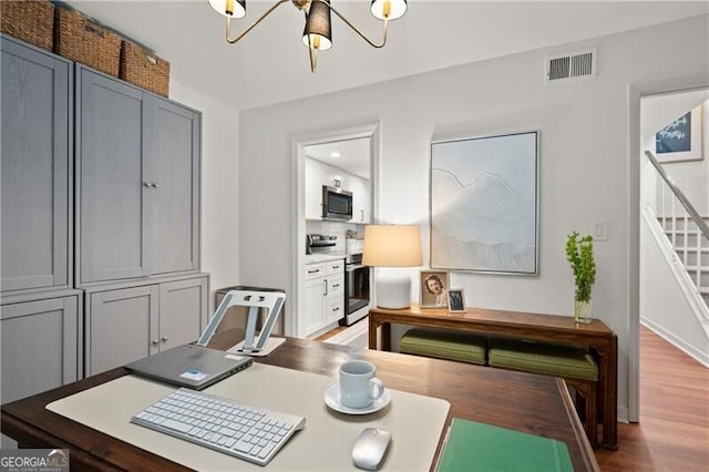 office area featuring wood-type flooring and a chandelier