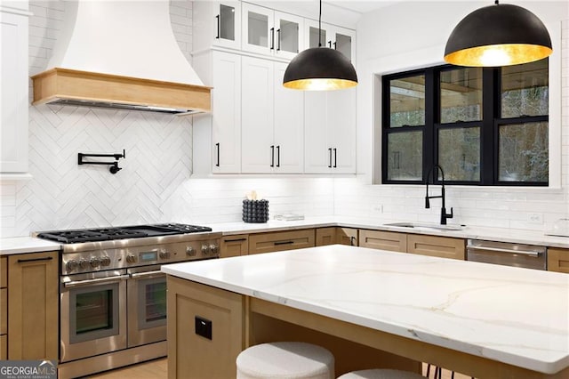 kitchen with stainless steel appliances, premium range hood, sink, and white cabinetry