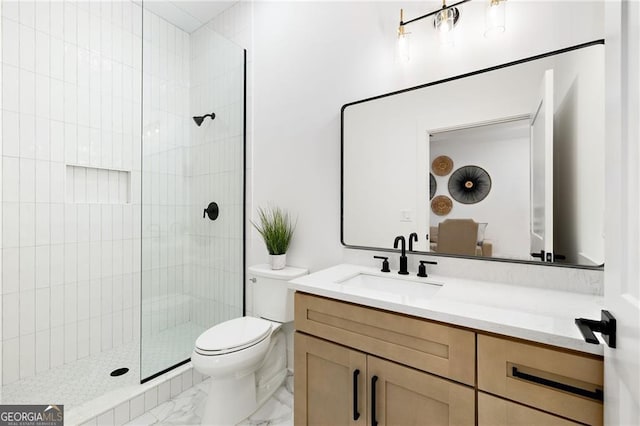 bathroom featuring vanity, toilet, and tiled shower