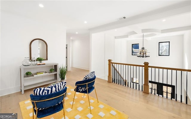 living area featuring hardwood / wood-style floors and a chandelier