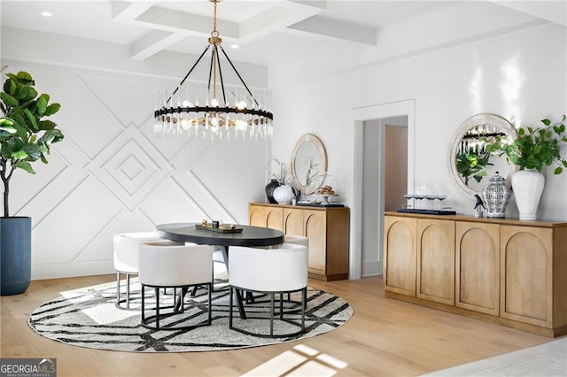 dining room featuring beamed ceiling, coffered ceiling, a chandelier, and light hardwood / wood-style floors