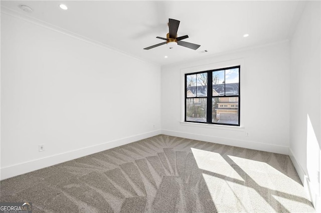 carpeted spare room with crown molding and ceiling fan