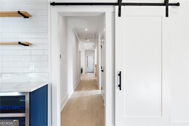 hall featuring a barn door and light hardwood / wood-style flooring