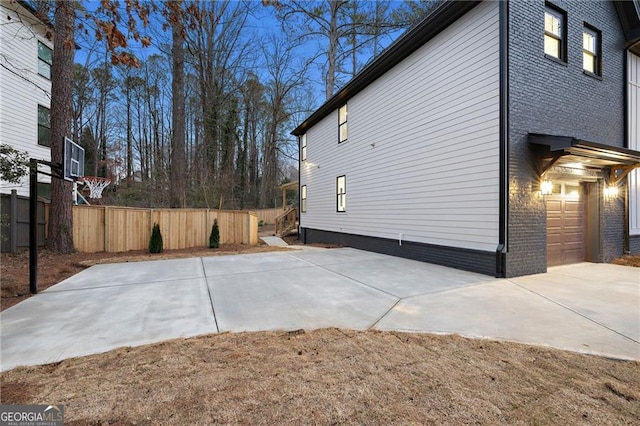 view of property exterior with a garage and basketball court