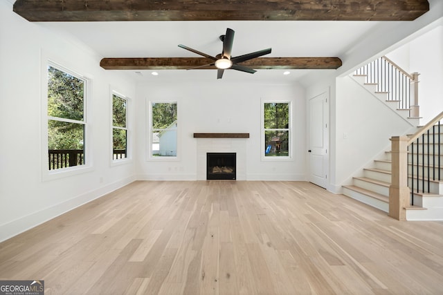 unfurnished living room with beam ceiling, ceiling fan, and light hardwood / wood-style floors