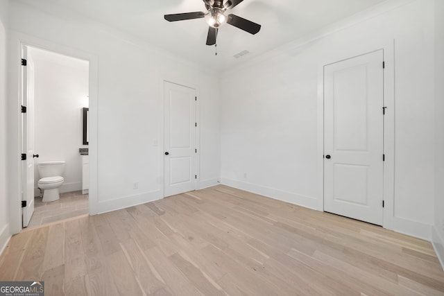 unfurnished bedroom featuring crown molding, connected bathroom, and light hardwood / wood-style flooring