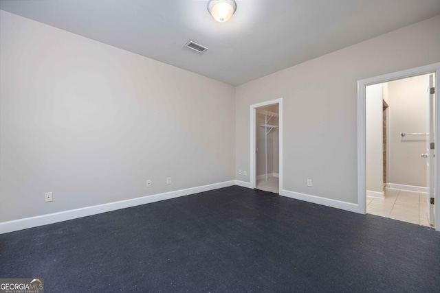 unfurnished bedroom featuring a spacious closet