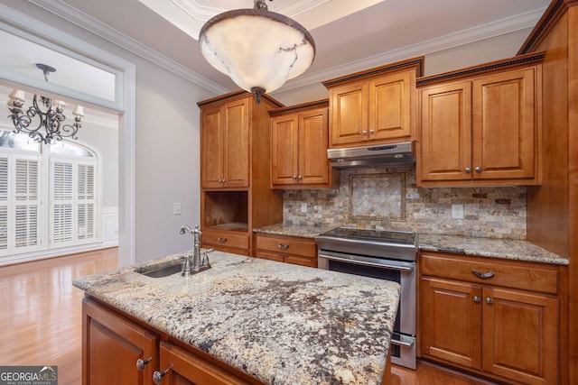 kitchen featuring pendant lighting, stainless steel electric range oven, sink, and light stone counters