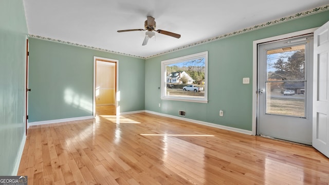 empty room with ceiling fan, a healthy amount of sunlight, and light wood-type flooring