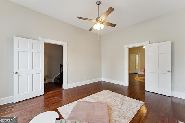 interior space with ceiling fan, lofted ceiling, and dark hardwood / wood-style flooring