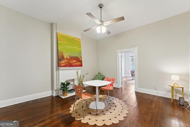 living area featuring dark hardwood / wood-style floors and ceiling fan