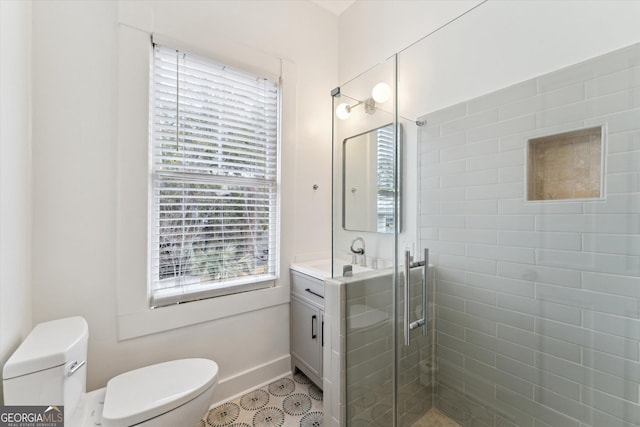 bathroom with walk in shower, vanity, and toilet