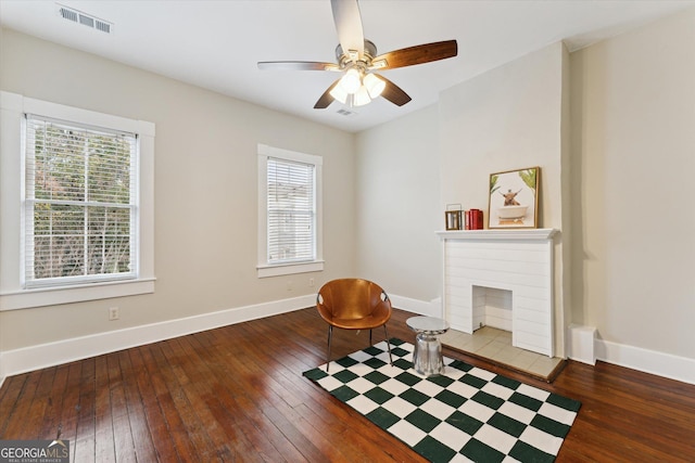 living area featuring plenty of natural light, dark wood-type flooring, and ceiling fan